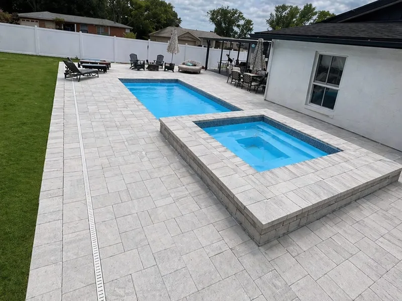 Light paver pool deck with raised spa and fiberglass pool