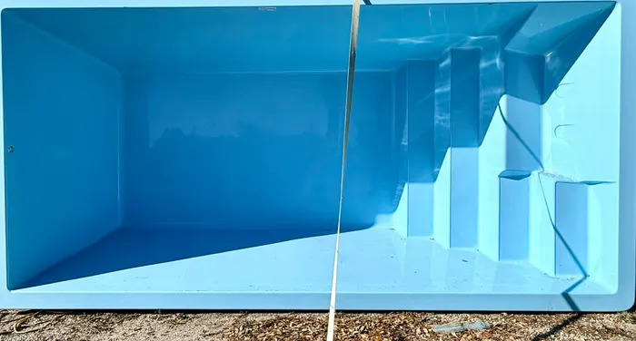Casco de piscina de fibra de vidrio azul en nuestro patio